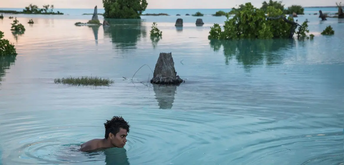 A 16-year-old child swims in the flooded area of Aberao village in Kiribati. The Pacific island is one of the countries worst affected by sea-level rise. A 16-year-old child swims in the flooded area of Aberao village in Kiribati. The Pacific island is one of the countries worst affected by sea-level rise.