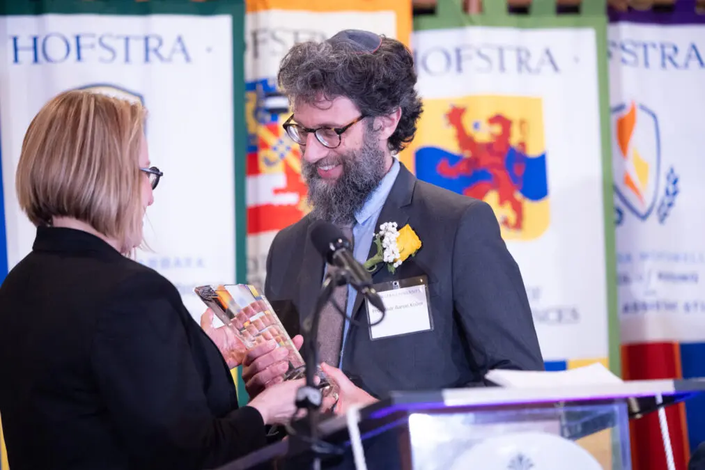 Dr Aaron Koller receiving the 2024 Guru Nanak Interfaith Prize from Eva Badowska