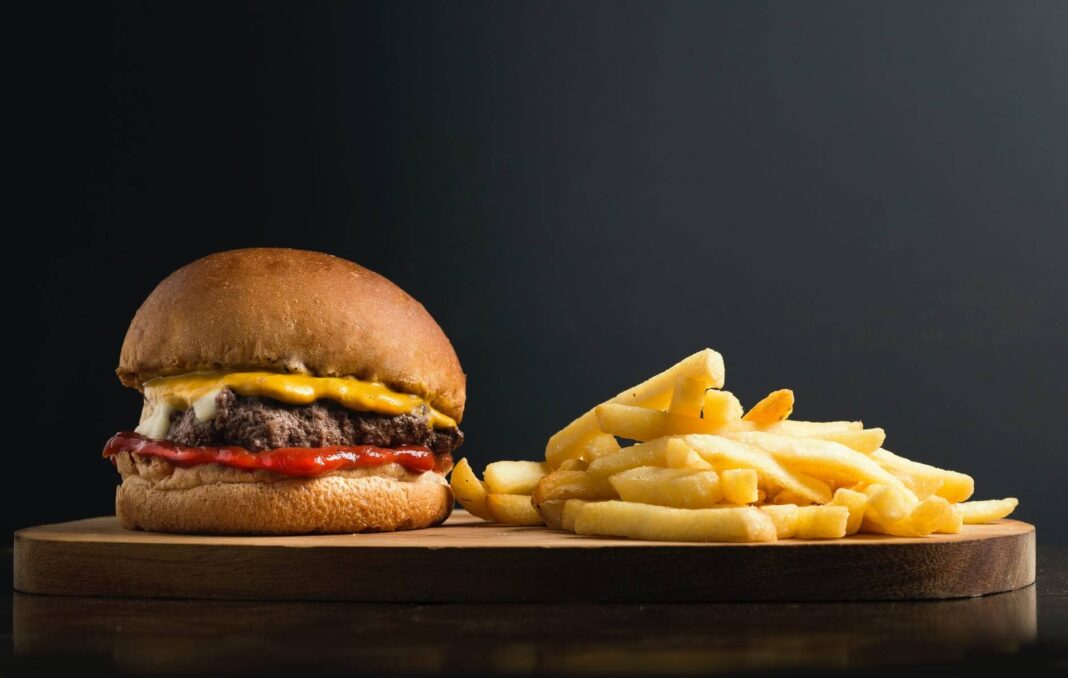classic hamburger and french fries on wooden board