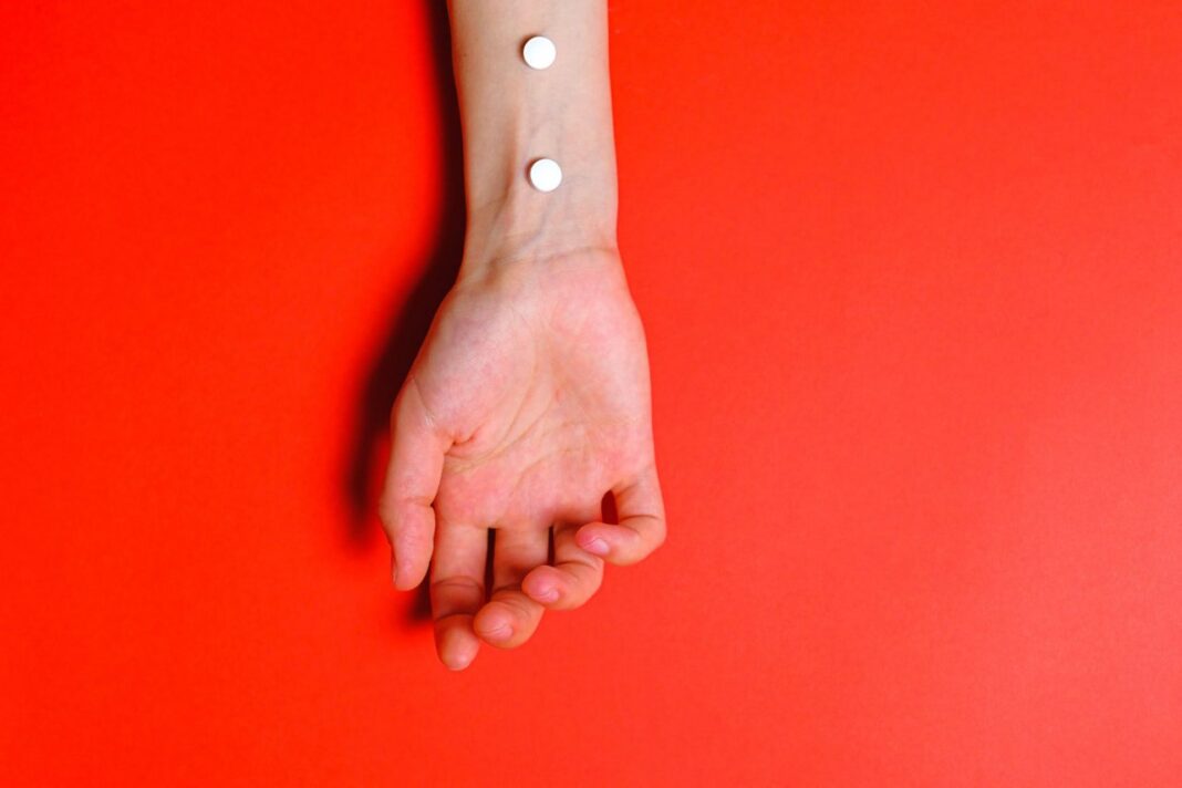 foto do braço da pessoa em fundo vermelho