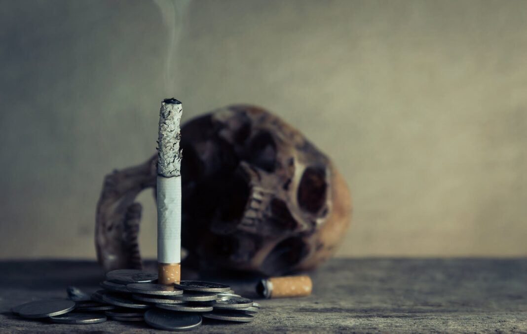 Zigarettenstummel auf Münzstapel