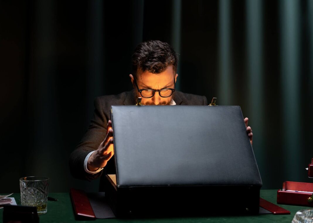 Человек в черной рубашке с длинным рукавом с черным портативным компьютером