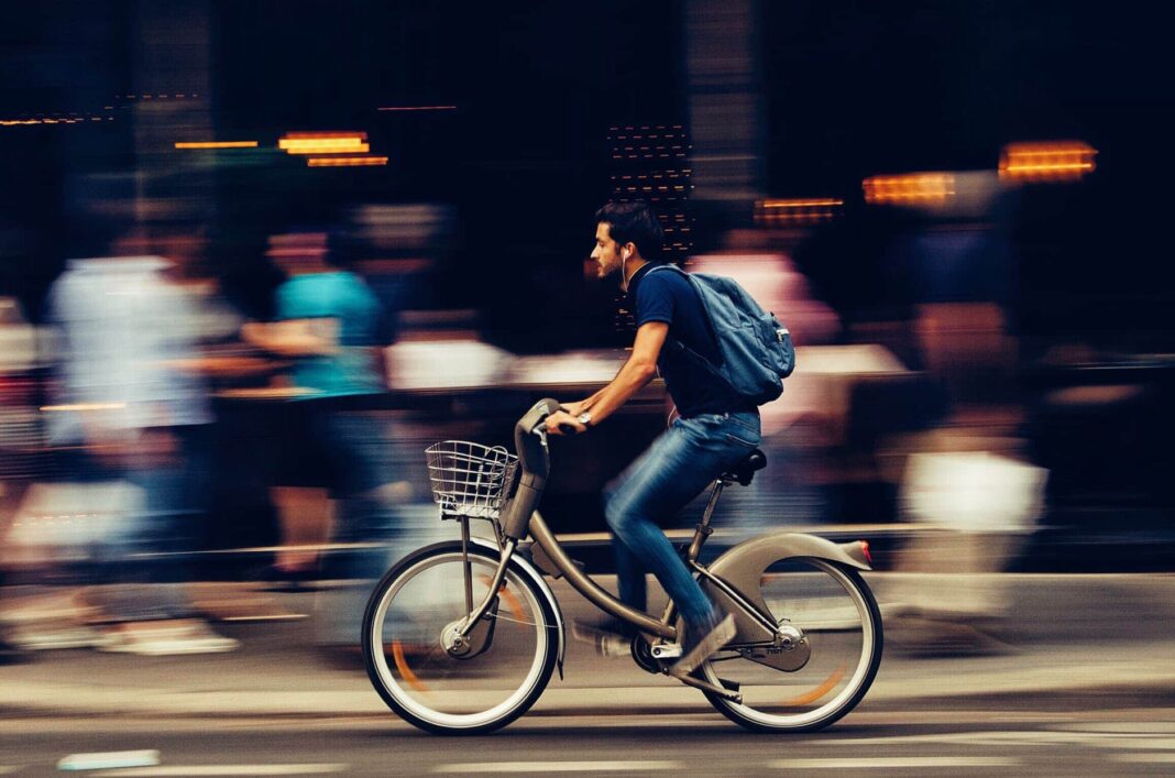 férfi kerékpározás a város utcáján