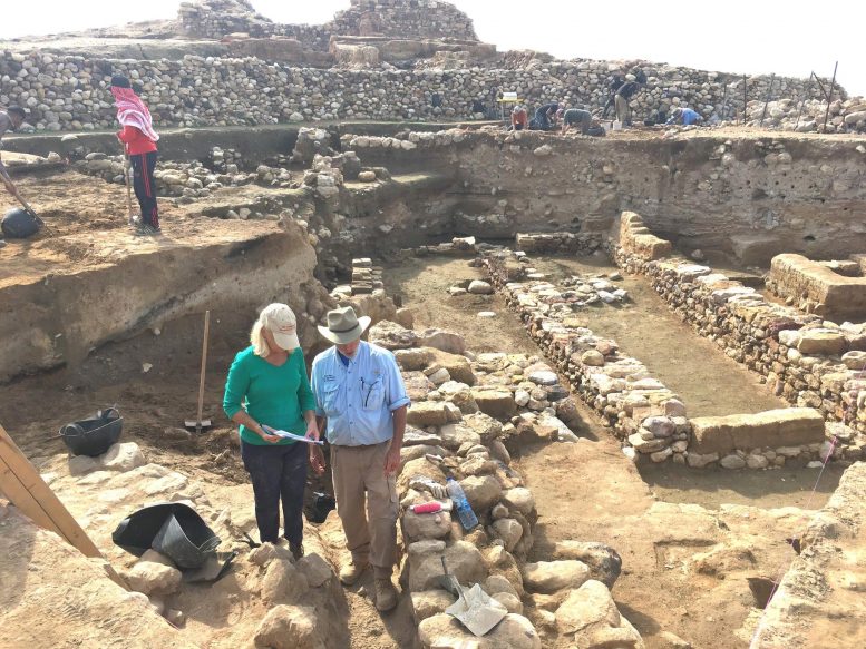 Исследователи стоят у руин древних стен