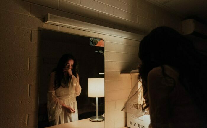 woman suffering looking at mirror