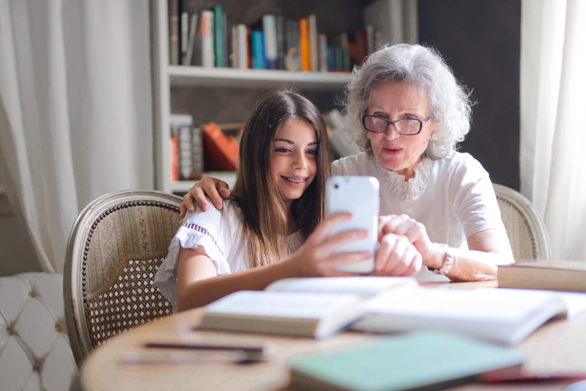 photo of woman showing her cellphone to her grandmother