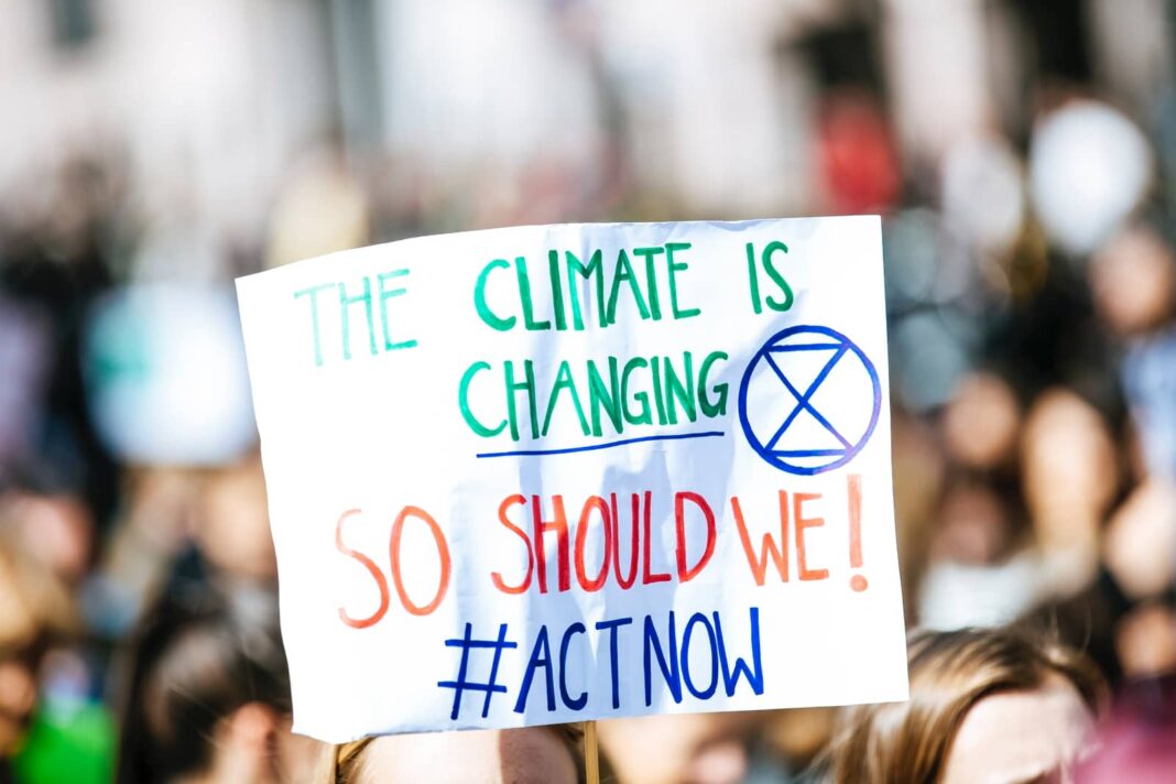 شخص يحمل لافتات The Climate is Changing