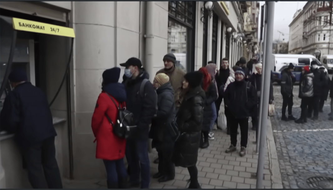 people waiting in line at an ATM in Russia