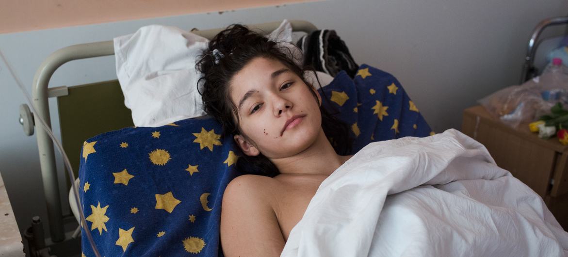 Поранена дівчина лежить у медичному відділенні в Києві, Україна, після того, як її автомобіль обстріляли.