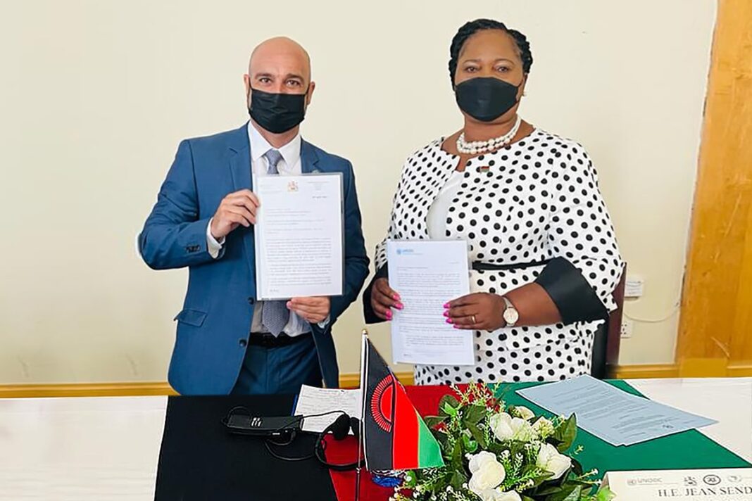 Mr. Marco Teixeira, Head of UNODC Office in Mozambique and H.E. Jean Sendeza, Minister of Homeland Security of Malawi, holding letters signifying a commitment to strengthen cooperation between UNODC and the Government of Malawi