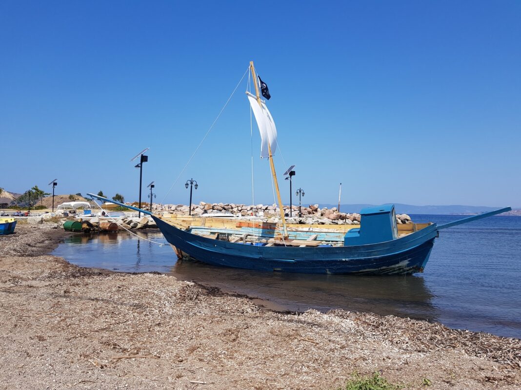 barca blu e bianca sulla spiaggia durante il giorno