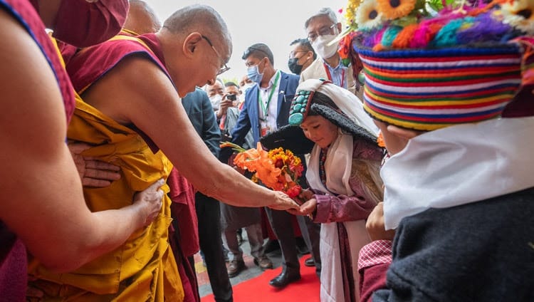 Sy Heiligheid die Dalai Lama groet 'n jong Ladakhi-meisie in tradisionele drag terwyl hy op 29 Julie 2022 vir die tweede dag van onderrig by die Shewatsel-onderrigterrein in Leh, Ladakh, UT, Indië aankom. Foto deur Tenzin Choejor