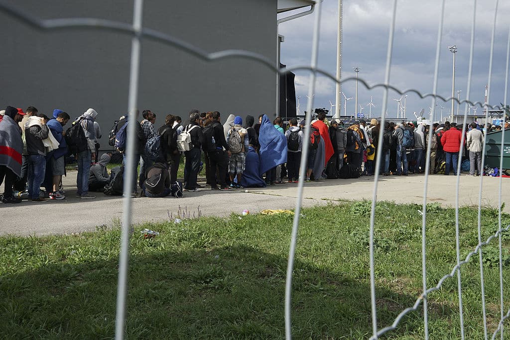 Eine Reihe syrischer Flüchtlinge überquert auf ihrem Weg nach Deutschland die Grenze zwischen Ungarn und Österreich. Ungarn, Mitteleuropa, 6. September 2015