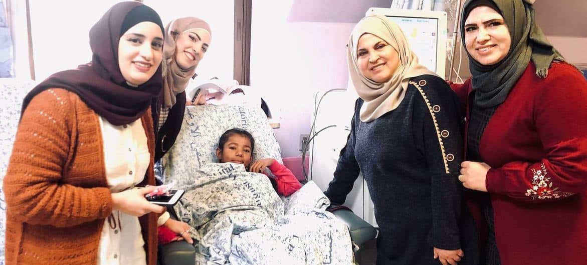 パレスチナのオーガスタ・ビクトリア病院で彼女の決定学校の教師と一緒にいる 11 歳のシャハド。
