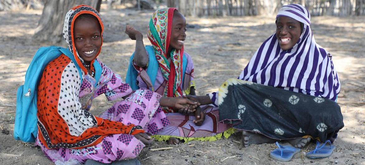 Hadjé, Achta und Ngoleram sitzen unter einem Baum im Tschad und genießen den Schatten und die frische Luft des Sees.