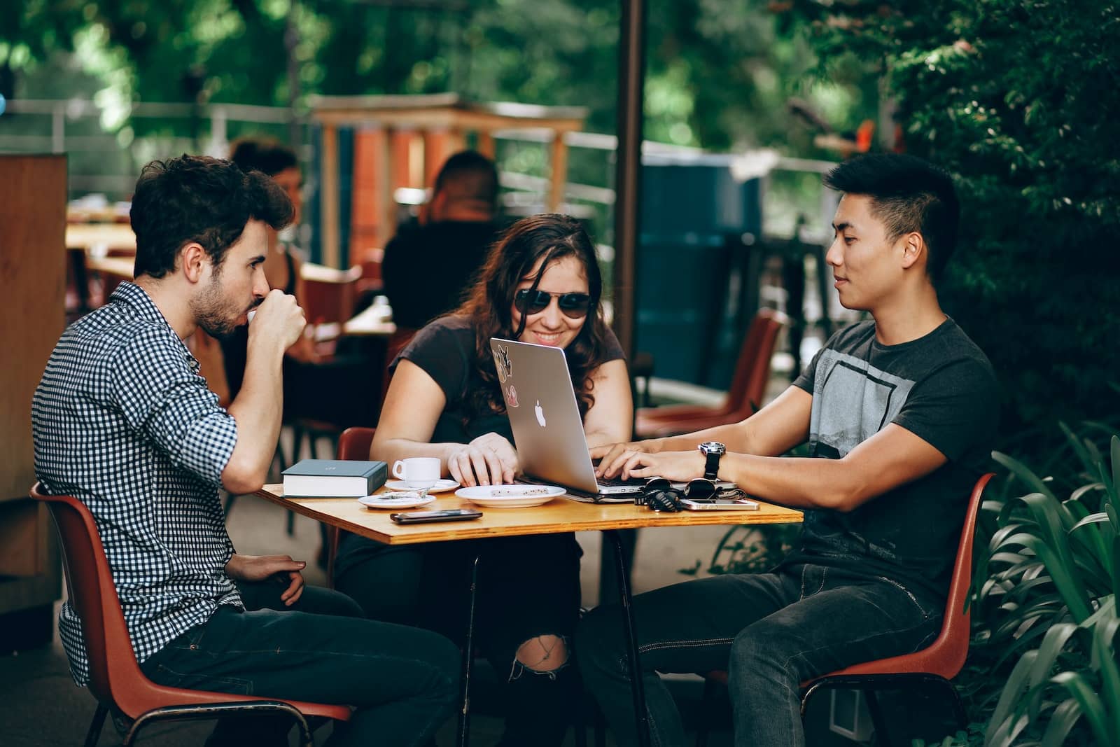 photo of three millennials sitting and talking while planning work