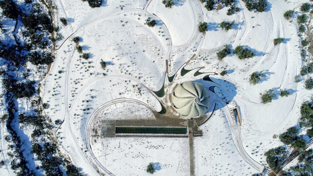 aerial photography of grey concrete structure surrounded by trees at daytime