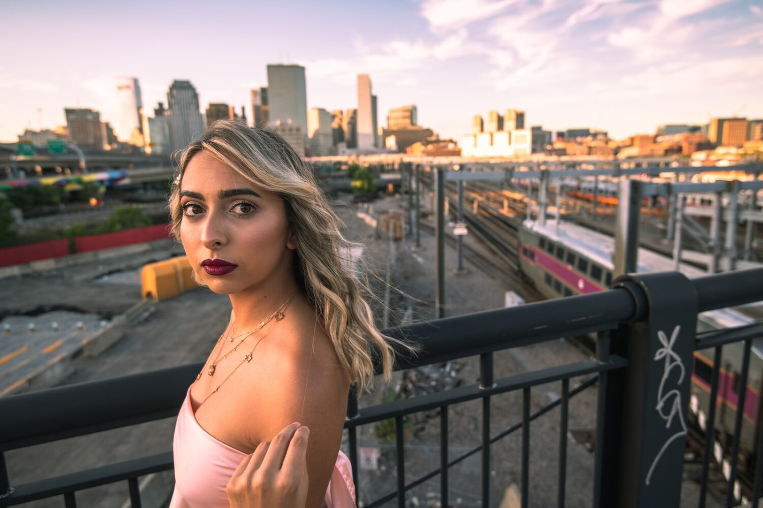 woman in white brassiere leaning on black metal railings during daytime