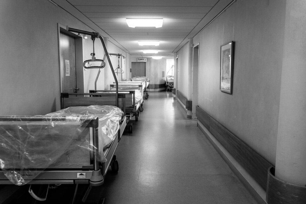 foto in scala di grigi del letto d'ospedale
