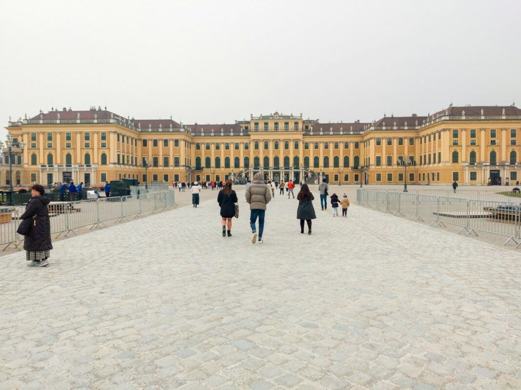 a group of people walking across a stone walkway